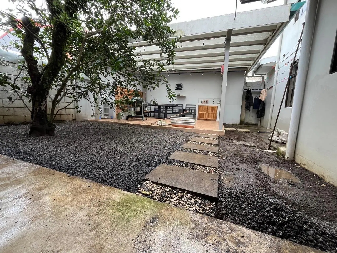 Antes: patio interno con tierra y piedras
