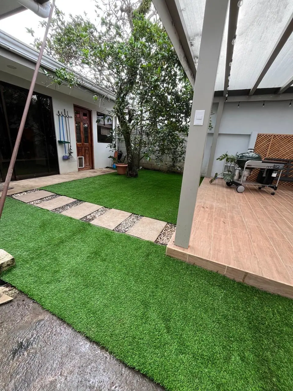 Después: patio interno con césped artificial por Jardines BR