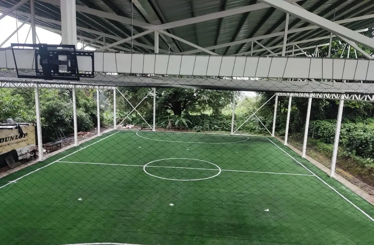 Cancha de fútbol con césped sintético bajo techo instalada por Jardines BR